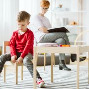Niño con autismo sentado en una silla en un salón de clases en terapia