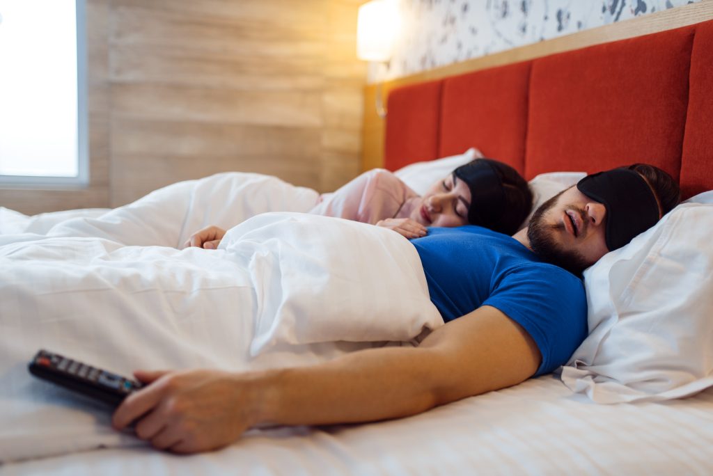 Pareja de amor durmiendo en cubiertas para los ojos en la cama en casa, un sueño saludable y confortable. Relación armoniosa en la familia joven. Hombre y mujer descansando juntos en su casa, fin de semana sin preocupaciones